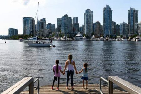 Mother and daughters travelling in Vancouver, British Columbia. Family with Vancouver skyline.